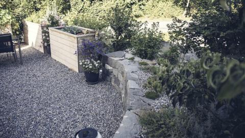 Sitzplatz mit Hochbeet und Trockenmauer
